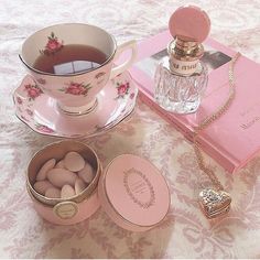 a tea cup and saucer on a bed next to an empty box with eggs in it