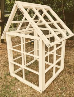 a white chicken coop in the grass