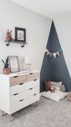 a white dresser sitting next to a wall with a christmas tree on top of it