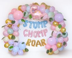 a bunch of balloons that are in the shape of a wreath with words stomp chomp roar