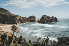 the beach is next to some big rocks