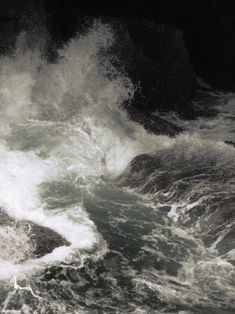 black and white photo of waves crashing into the shore