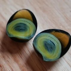 two pieces of fruit sitting on top of a wooden table