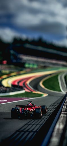 a red race car driving down a track