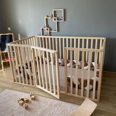 a baby crib in the middle of a room with toys on the floor next to it