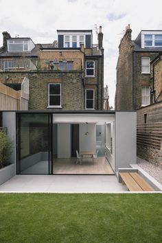 an open courtyard in the middle of a city with lots of grass and buildings around it