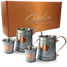 three metal mugs sitting next to each other in front of a box with the word globose designs on it