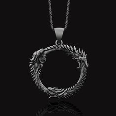 "Silver Elder Scrolls Online Inspired Necklace, Dragonborn Pendant, Dragon Ring, Skyrim Gift, Video Game Jewelry, Valentine's Day Gift ✦ Jewelry Details ✦ * Material: 925 Sterling Silver * Front Dimensions: Length 35x35mm * Weight: 10-11 grams * Finish: Oxidized, Polished, Gold * Stamp: 925 * Ideal for daily use with an oxidized finish on 925 sterling silver, which makes details more attractive eye-catching! * It can be made in 8K - 10K - 14K - 18K white/rose/yellow gold as well. Contact me! ✦ S Symbolic Round Hand Forged Jewelry, Collectible Oxidized Pendant Jewelry, Symbolic Hand-forged Black Jewelry, Symbolic Hand Forged Black Jewelry, Oxidized Finish Round Pendant Jewelry For Gift, Collectible White Gold Round Pendant Jewelry, Collectible Round Symbolic Jewelry, Hand Forged Round Pendant Jewelry For Anniversary, Round Oxidized Jewelry Gift