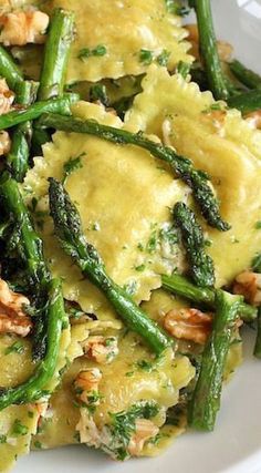 a white plate topped with pasta and asparagus