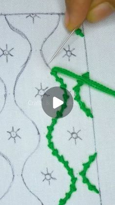 someone is stitching something with green thread