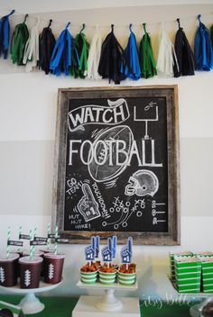 a football themed party with tassels and cupcakes on the table in front of a chalkboard