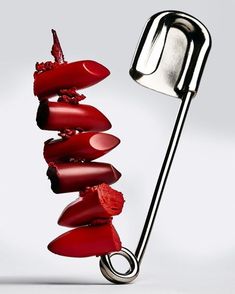 a metal object with red lipstick on it's side and a toothpick sticking out of it