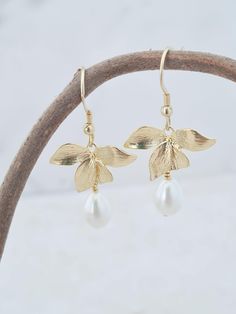 These earrings make a thoughtful gift for someone special. Symbolising love, beauty and strength. They are pretty and dainty with a pearl teardrop. Perfect bridesmaid earrings. The earrings are gold plated and the pearl is white and measure 1.5in in length. The earrings are gold plated and the pearl is white. Your jewellery will arrive in a gift box ready for giving. This item ships from the UK within 1 working day. Flower Pearl Earrings, Orchid Earrings, Gold Orchid, Flower Drop Earrings, Gifts Bridesmaid, Clothes Pictures, Earrings Flower, Earrings Dainty, Mom Gifts