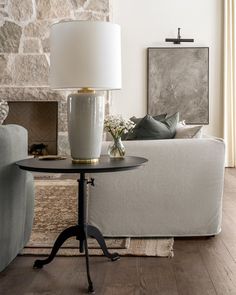 a living room with a couch, table and lamp in it's centerpiece