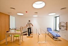 a man is walking down the stairs in an empty room with blue chairs and tables