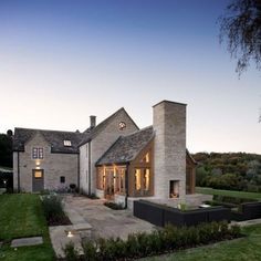 a large brick house with an outdoor seating area and fire pit in the front yard