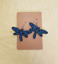 pair of blue dragonfly earrings sitting on top of a card