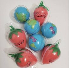 six plastic strawberries with designs on them