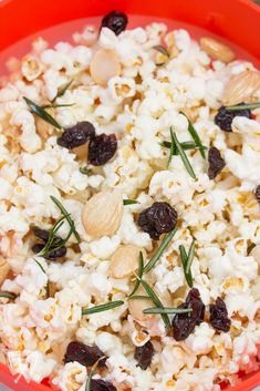 a red bowl filled with popcorn and raisins