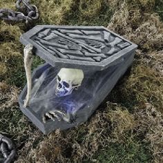 there is a skull in the ground with chains around it and an object on top