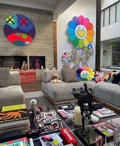 a living room filled with lots of furniture next to a wall mounted art piece on the wall