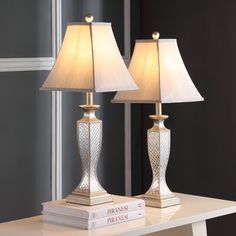 two lamps sitting on top of a white table