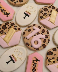 decorated cookies are arranged in the shape of leopard print and pink, white, and gold