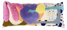 a decorative pillow with different colors and shapes on the front, sitting on a white background