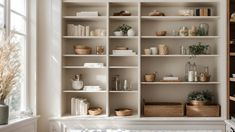 a white bookcase filled with lots of books next to a window in a room