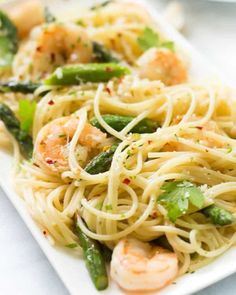 pasta with shrimp and asparagus on a white plate