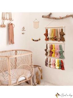 a baby crib with clothes hanging on the wall next to an infant crib