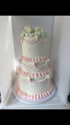 a three tiered wedding cake with pink ruffles