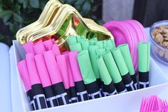 a box filled with lots of pink, green and gold paper straws on top of a table