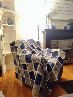 a blue and white blanket sitting on top of a wooden floor next to a fireplace