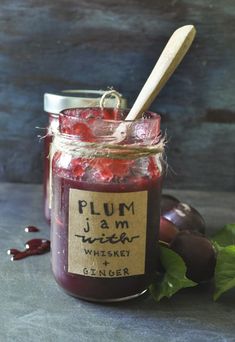 plum jam in a glass jar with a wooden spoon