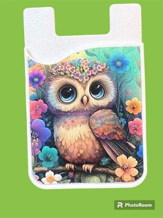 an owl with flowers on it's head is sitting on a branch in front of a green background