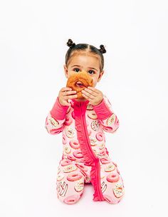 Get ready for sweet dreams with this A-dough-rable print. The vibrant donuts on this pajama set adds a touch of whimsy and sweetness that your little one will love. Designed to be as soft as cuddles, this convertible footie is made with the coziest, snuggliest bamboo viscose fabric. Our footie features fold-over foot cuffs and mittens, so you can easily transition from sleep to play. The stretchy fit and the luxurious fabric feel gentle on your baby’s delicate skin, while the 2-way double zipper Playful Pink Onesie For Pajama Party, Playful Pink Onesie For Sleep, Playful Long Sleeve Onesie For Sleepovers, Pink Sweet Sleepwear For Bedtime, Sweet Pink Sleepwear For Bedtime, Sweet Pink Sleepwear For Sleepover, Pink Cotton Onesie For Pajama Party, Cute Onesie For Pajama Party, Playful Pink Onesie For Playwear