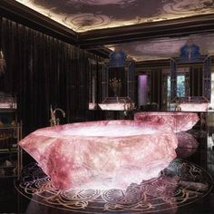 a large bath tub sitting inside of a bathroom next to two sinks and mirrors on the wall