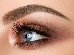 a woman's eye with long lashes and blue eyeshadow