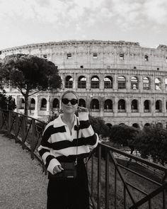 a woman standing in front of the colossion with her hand on her head