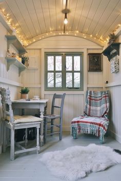 a chair and table in a room with lights on the ceiling