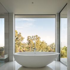 a large white bath tub sitting next to a window