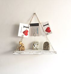 a white shelf with some animal figurines hanging from it's sides and cards attached to the shelves