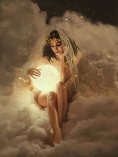 a woman sitting on top of clouds holding a light ball in her hand and looking at the camera