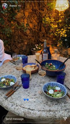 a man sitting at a table with bowls of food and drinks in front of him