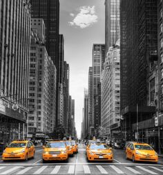 black and white photograph of taxi cabs in new york city with skyscrapers behind them