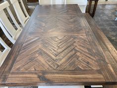 a wooden table with white chairs around it