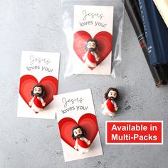 three valentine's day cards with the words jesus loves you and two small dolls holding a heart