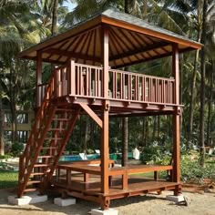 a wooden gazebo with stairs to the top and bottom floor, surrounded by palm trees