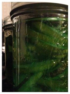 a jar filled with green beans sitting on top of a counter